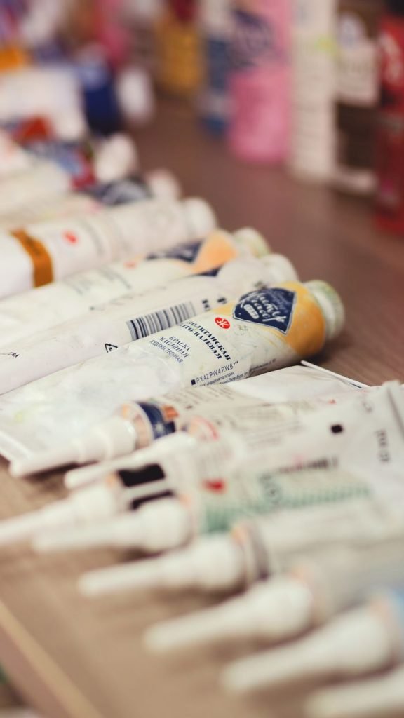 Various artist paint tubes spread on a wooden table, perfect for creative projects.